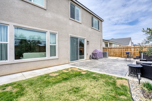 exterior space featuring fence, central air condition unit, stucco siding, a yard, and a patio