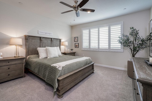 bedroom with a ceiling fan, light colored carpet, and baseboards