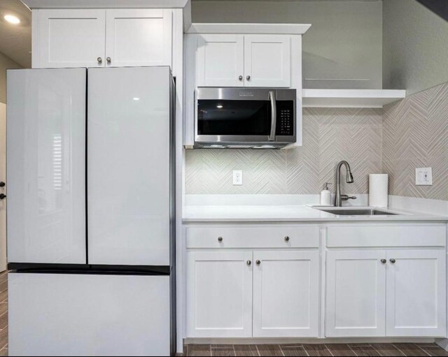 1093 Traverse Dr S, Madera, CA 93636 - kitchen featuring white cabinets, a sink, light countertops, freestanding refrigerator, and stainless steel microwave