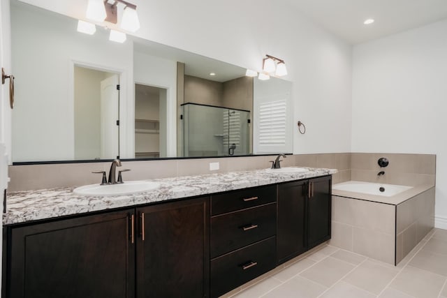bathroom with double vanity, tile patterned flooring, a shower stall, and a sink