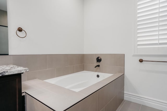 full bathroom with tile patterned floors, baseboards, a garden tub, and vanity