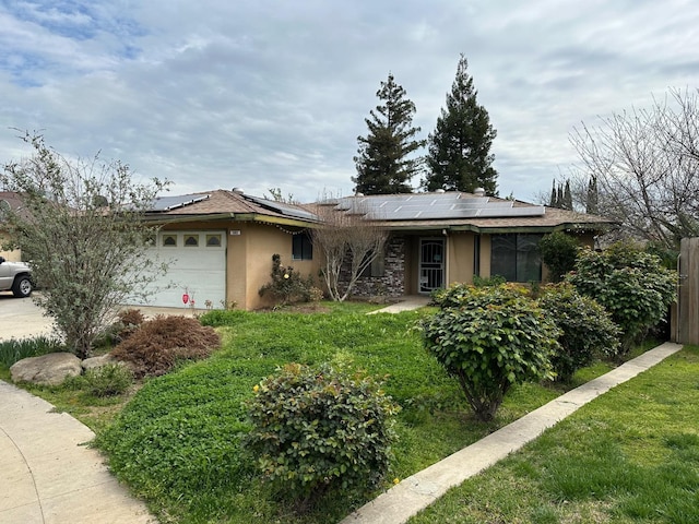 ranch-style house with stucco siding, solar panels, and a garage