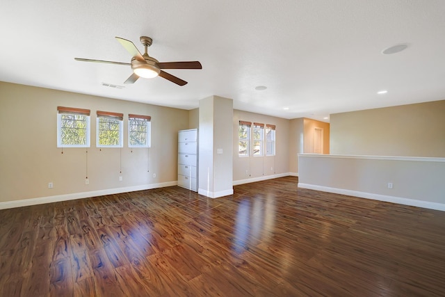 empty room featuring visible vents, baseboards, a ceiling fan, and wood finished floors