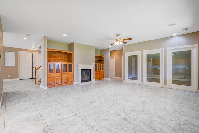 unfurnished living room with visible vents, marble finish floor, a glass covered fireplace, recessed lighting, and ceiling fan