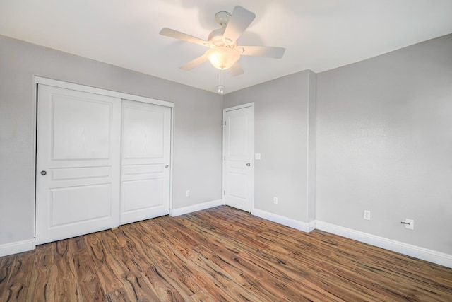 unfurnished bedroom featuring a closet, a ceiling fan, baseboards, and wood finished floors