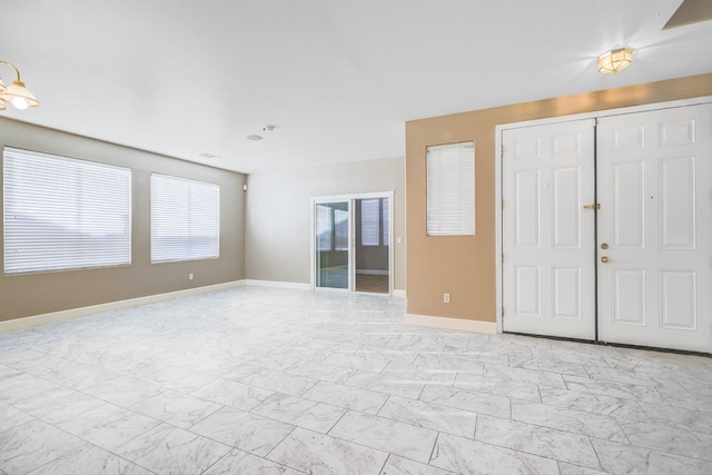 entrance foyer with baseboards and marble finish floor