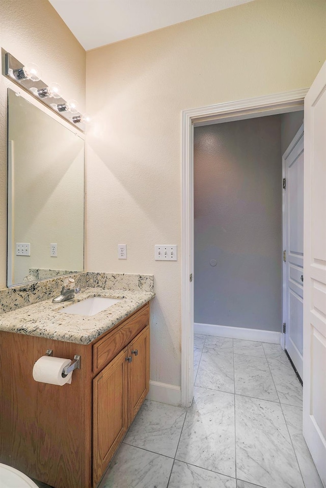 bathroom featuring vanity, baseboards, and marble finish floor