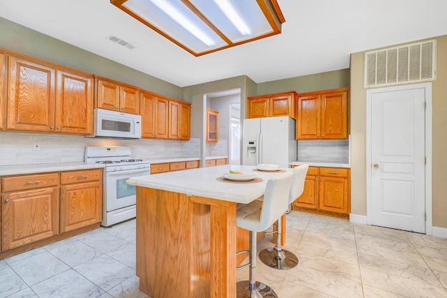 kitchen with white appliances, visible vents, marble finish floor, and light countertops