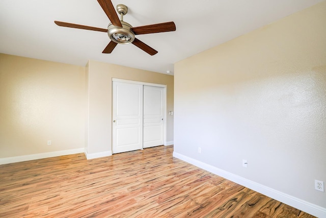 unfurnished bedroom with a closet, baseboards, light wood finished floors, and ceiling fan