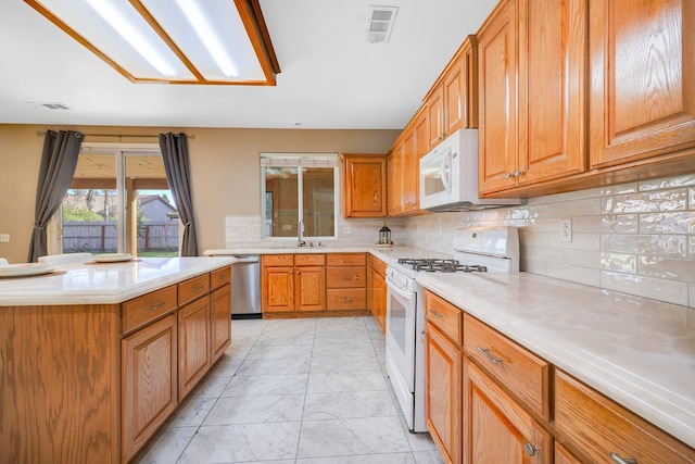 kitchen with visible vents, marble finish floor, a sink, white appliances, and light countertops