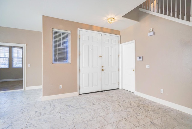 entryway featuring baseboards and marble finish floor