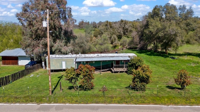 view of front of house with metal roof, a front lawn, and fence