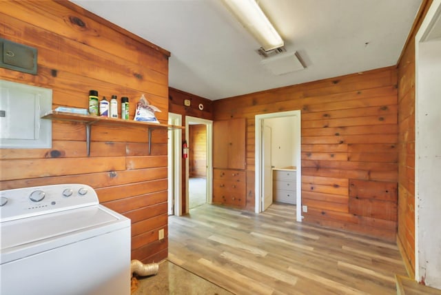 clothes washing area with light wood-type flooring, visible vents, washer / clothes dryer, wood walls, and laundry area