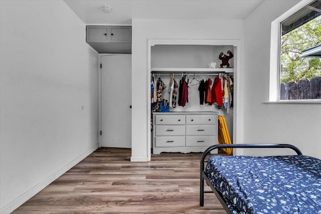 bedroom featuring a closet, baseboards, and wood finished floors