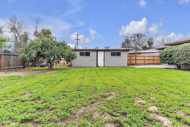 view of yard featuring a patio, an outdoor structure, and a fenced backyard