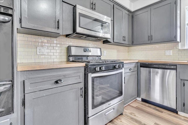 kitchen with decorative backsplash, gray cabinets, and stainless steel appliances