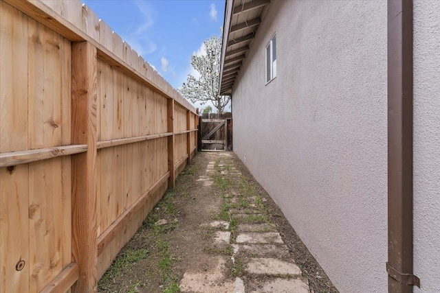 view of side of property with stucco siding and fence