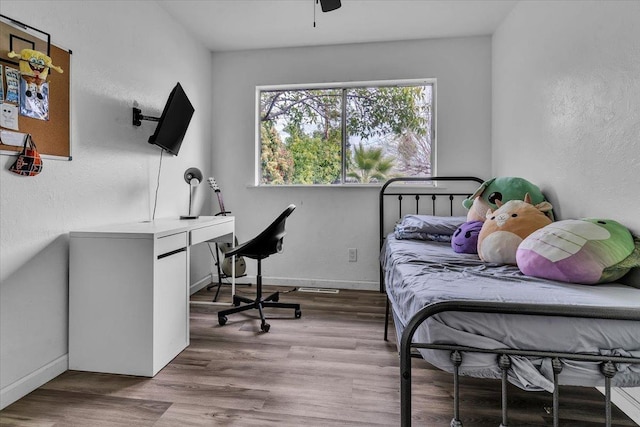 bedroom with baseboards and wood finished floors