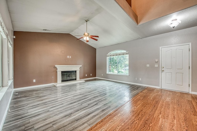 unfurnished living room featuring wood finished floors, a ceiling fan, baseboards, lofted ceiling, and a glass covered fireplace