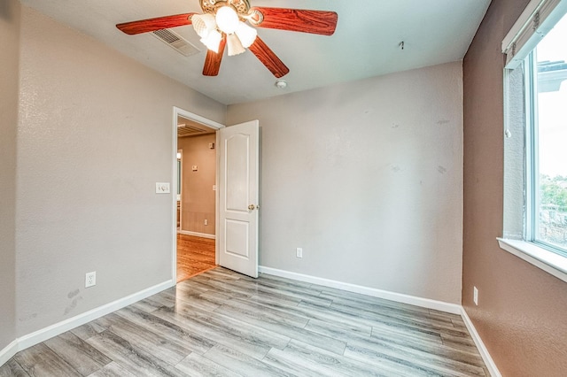 spare room with light wood-style flooring, baseboards, and ceiling fan