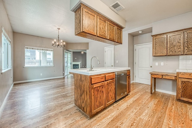 kitchen featuring a sink, visible vents, brown cabinets, and stainless steel dishwasher