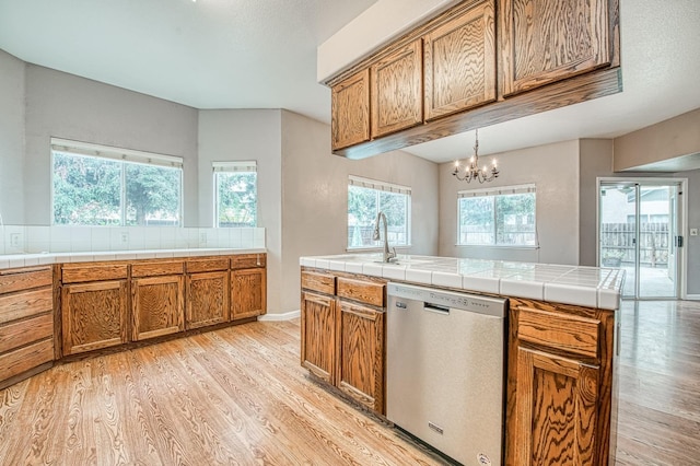 kitchen with light wood finished floors, brown cabinets, an inviting chandelier, and stainless steel dishwasher