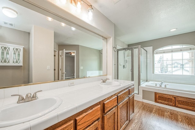 bathroom with visible vents, a shower stall, wood finished floors, and a sink