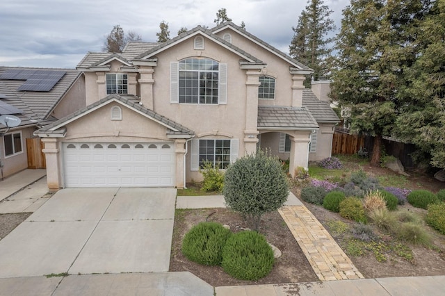 traditional-style house with a tiled roof, stucco siding, concrete driveway, and fence