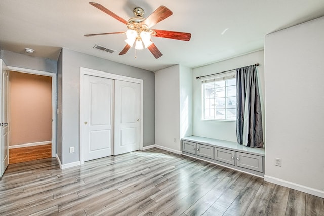 unfurnished bedroom with visible vents, a closet, light wood finished floors, baseboards, and ceiling fan