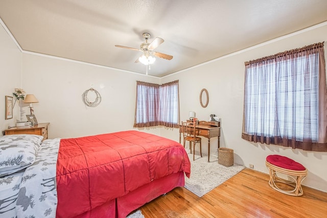 bedroom featuring ornamental molding, ceiling fan, and wood finished floors