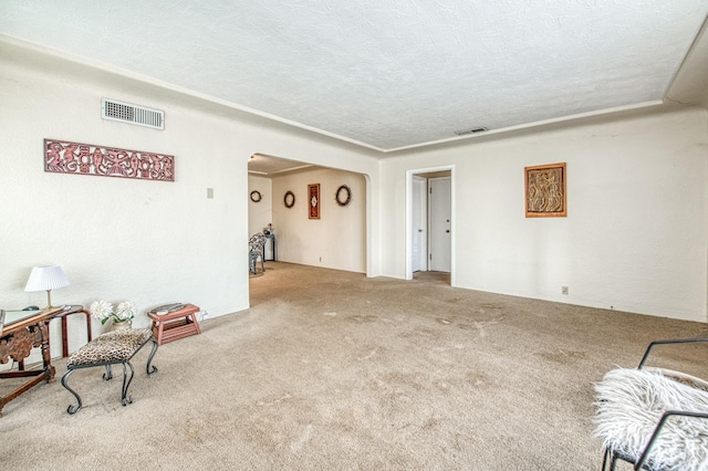 living area featuring arched walkways, visible vents, carpet floors, and a textured ceiling