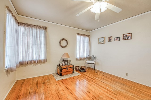 sitting room featuring crown molding, plenty of natural light, wood-type flooring, and ceiling fan