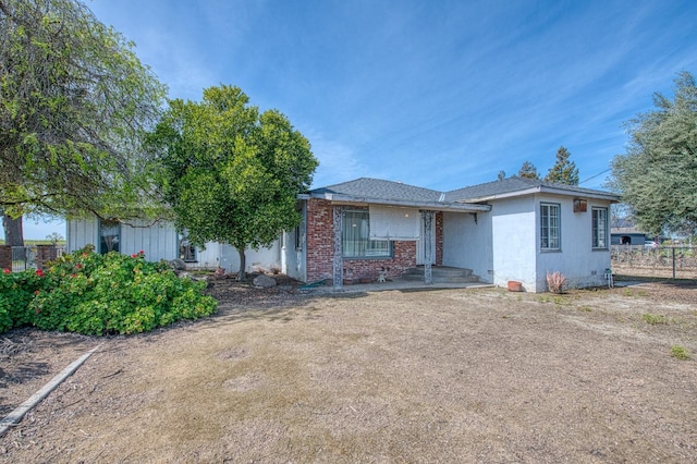 view of front of house with brick siding and fence