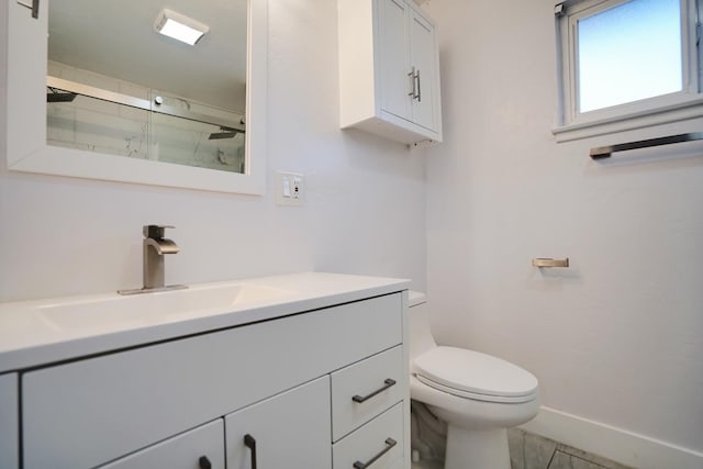 full bathroom featuring vanity, a shower stall, toilet, and baseboards