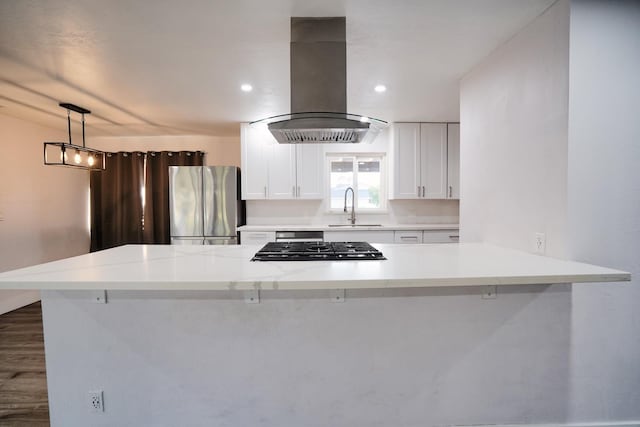 kitchen featuring island exhaust hood, a sink, white cabinetry, appliances with stainless steel finishes, and light countertops