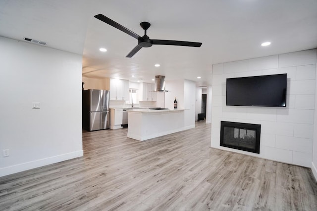 unfurnished living room featuring baseboards, visible vents, recessed lighting, ceiling fan, and light wood-type flooring