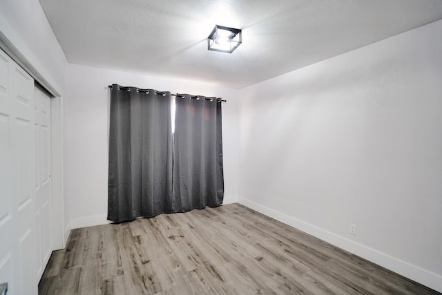 spare room featuring wood finished floors and baseboards