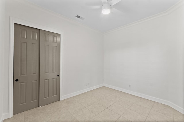 unfurnished bedroom with baseboards, visible vents, light tile patterned flooring, ornamental molding, and a closet