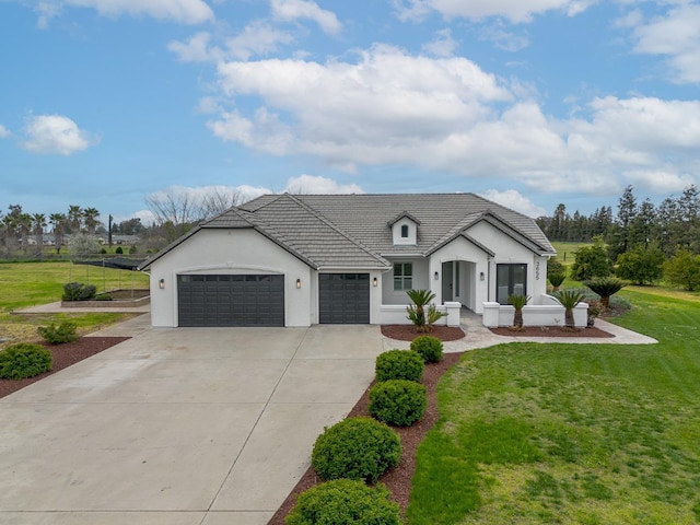 view of front of house featuring a front yard, an attached garage, a tile roof, and stucco siding