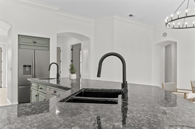 kitchen with white dishwasher, crown molding, visible vents, and a sink