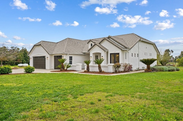 modern farmhouse style home with a front yard, a tiled roof, an attached garage, and driveway