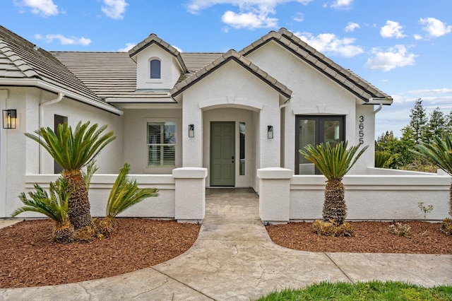 view of front of property featuring stucco siding and a tiled roof