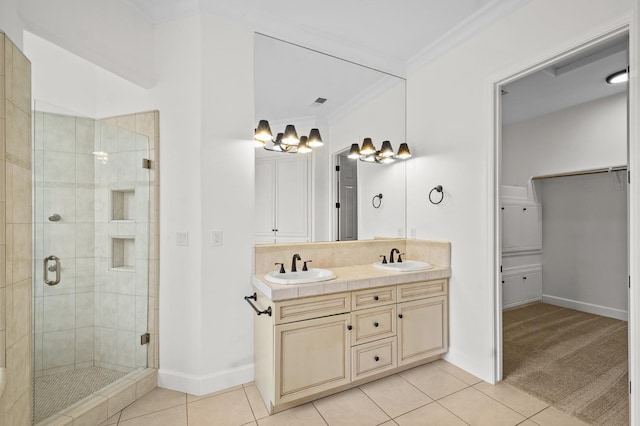 full bath featuring tile patterned floors, ornamental molding, a stall shower, and a sink