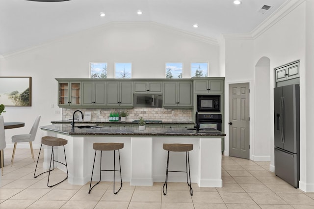 kitchen with a kitchen breakfast bar, black appliances, crown molding, and a sink