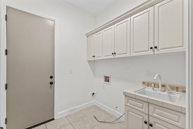 laundry room with light tile patterned floors, baseboards, cabinet space, a sink, and washer hookup