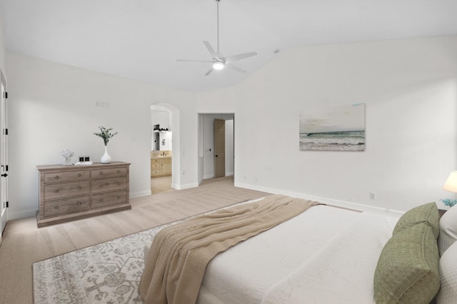 carpeted bedroom featuring vaulted ceiling, baseboards, arched walkways, and ensuite bathroom