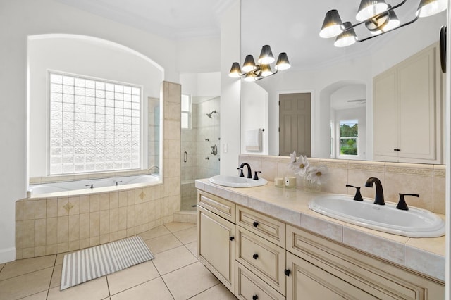 full bath featuring a sink, a shower stall, crown molding, a garden tub, and a chandelier