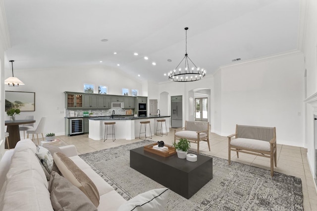 living area with arched walkways, light tile patterned floors, beverage cooler, and visible vents