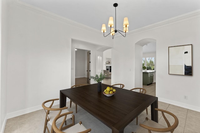 dining space featuring arched walkways, baseboards, and ornamental molding