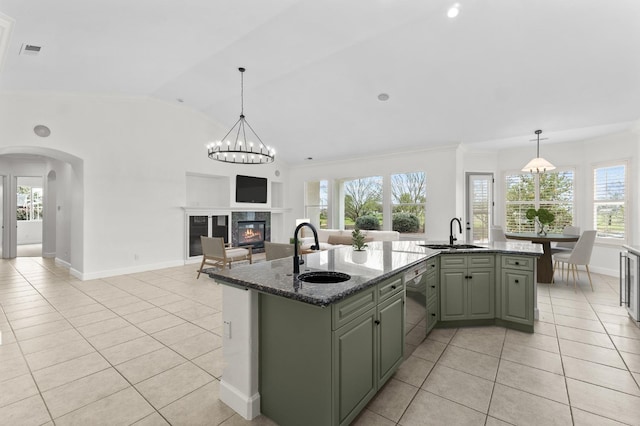 kitchen featuring a sink, dishwasher, an island with sink, and light tile patterned floors